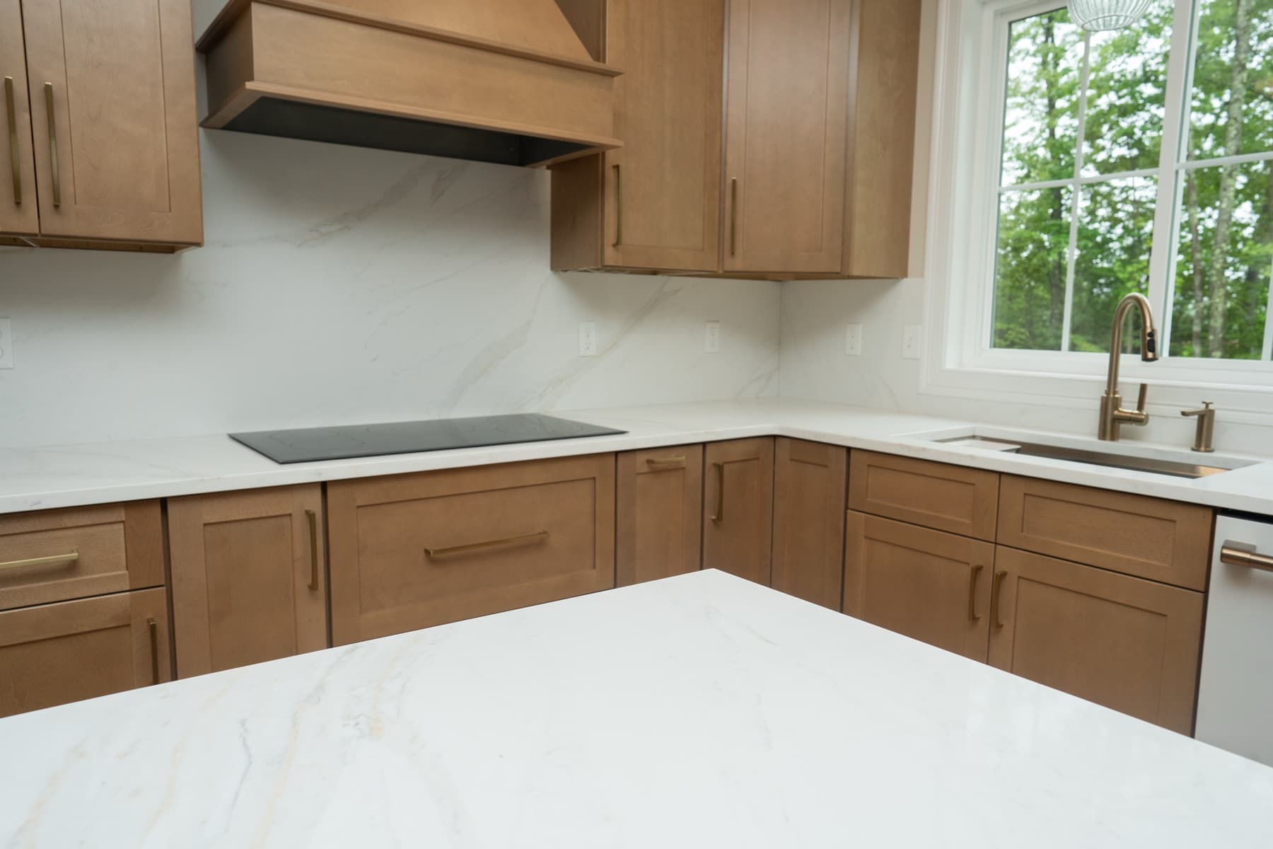 Calacatta Silverlight kitchen counters wrapping a corner with cooktop and sink window