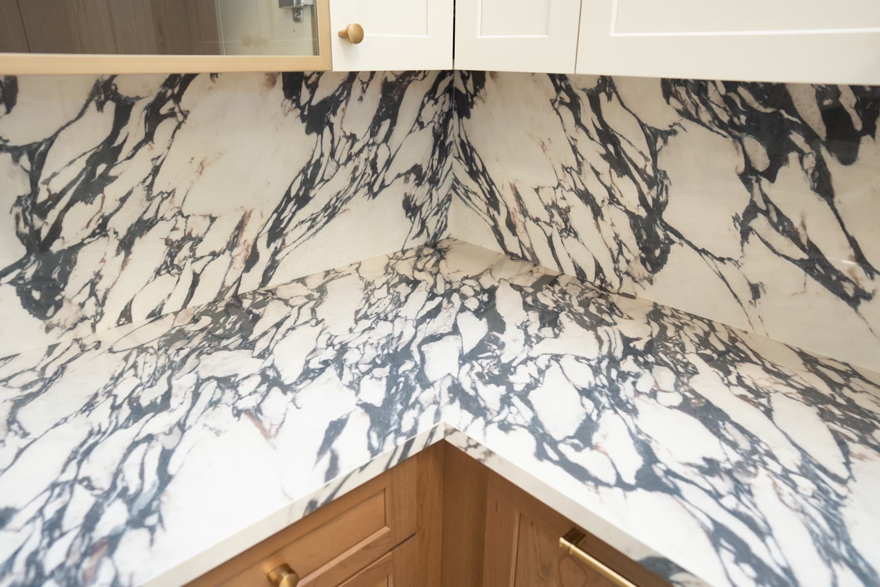 Corner detail of Calacatta Viola porcelain backsplash and countertop with bold veining