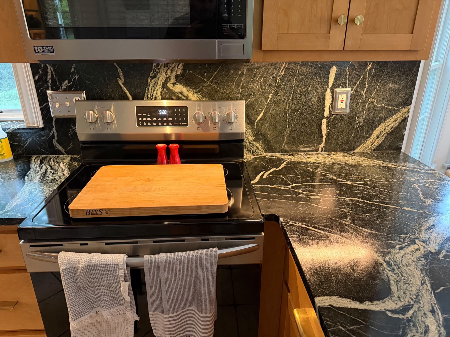 Grey Venato counters and full-height backsplash around a stainless range