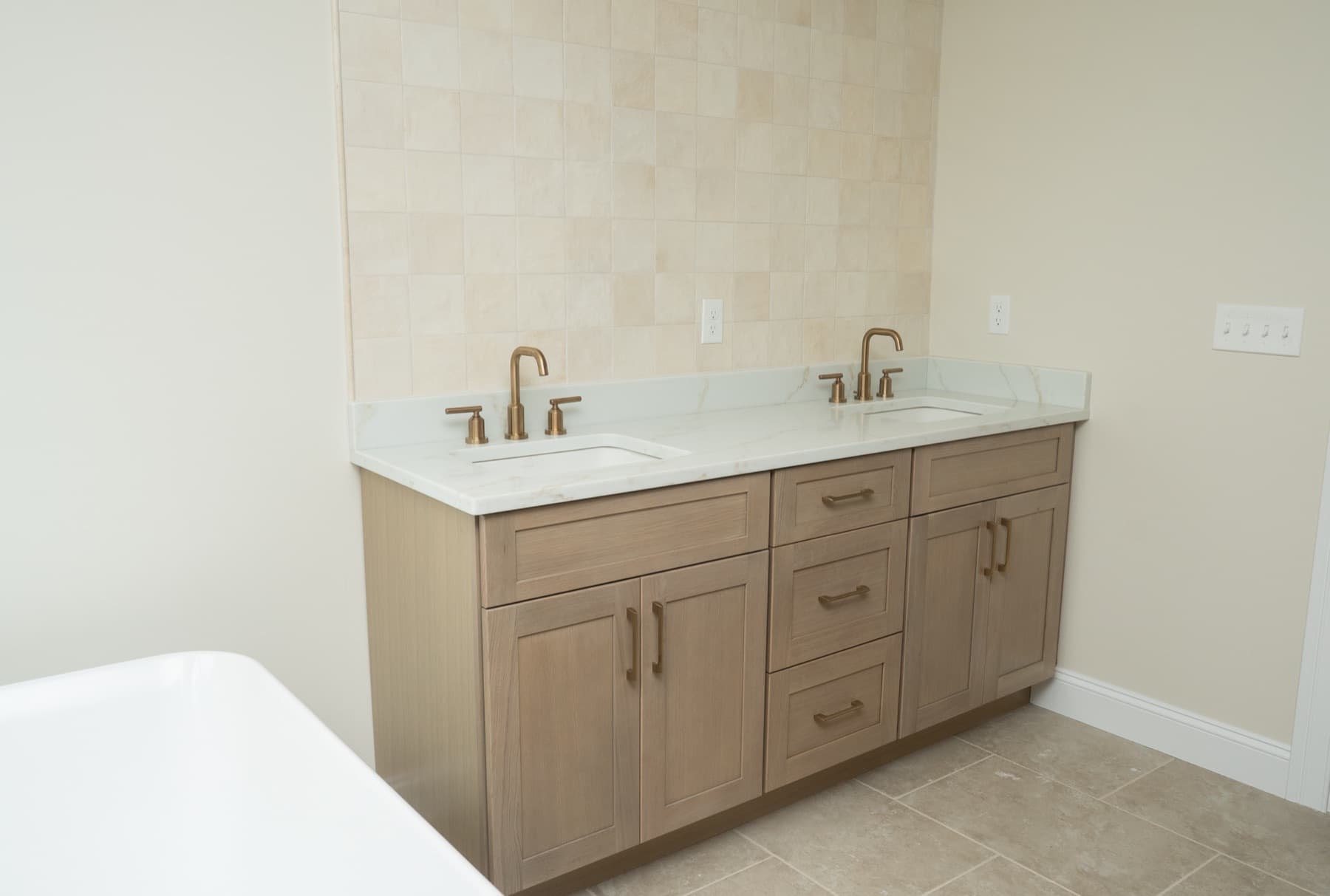 White oak double vanity with Jasper quartz countertop beside a freestanding tub