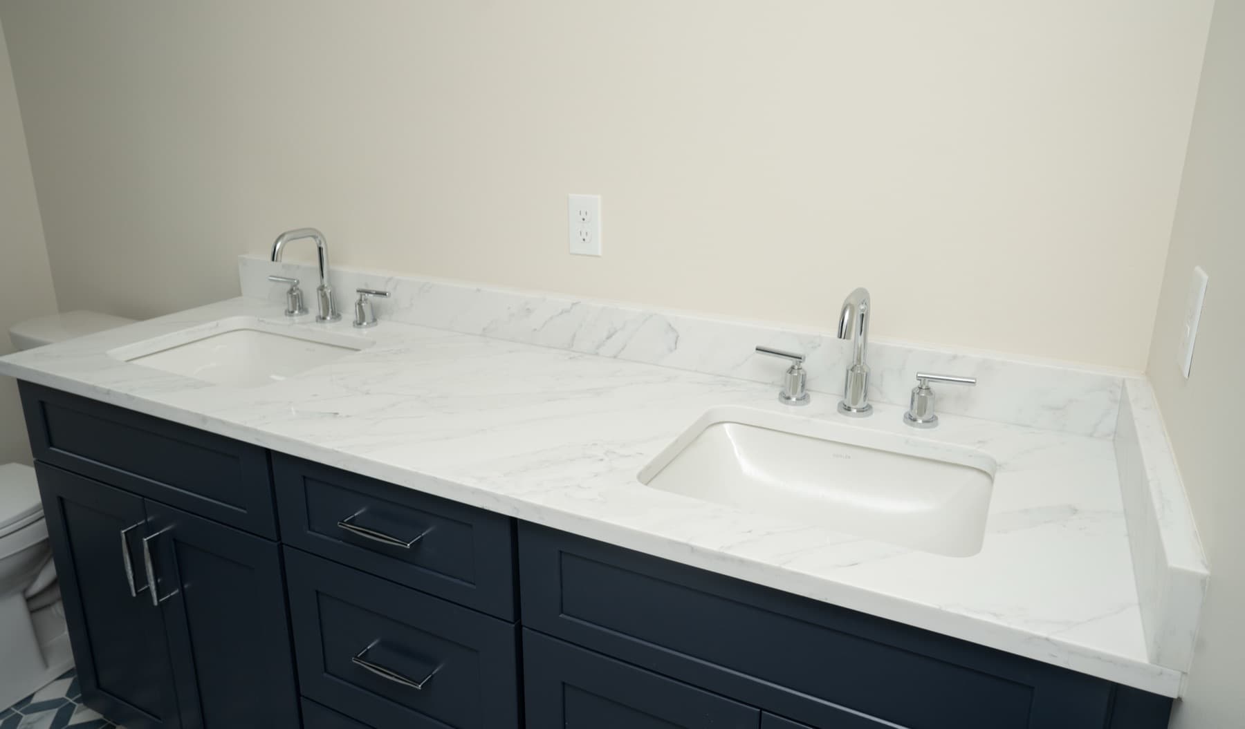 Navy double vanity with a Marfil Grey quartz countertop and chrome faucets