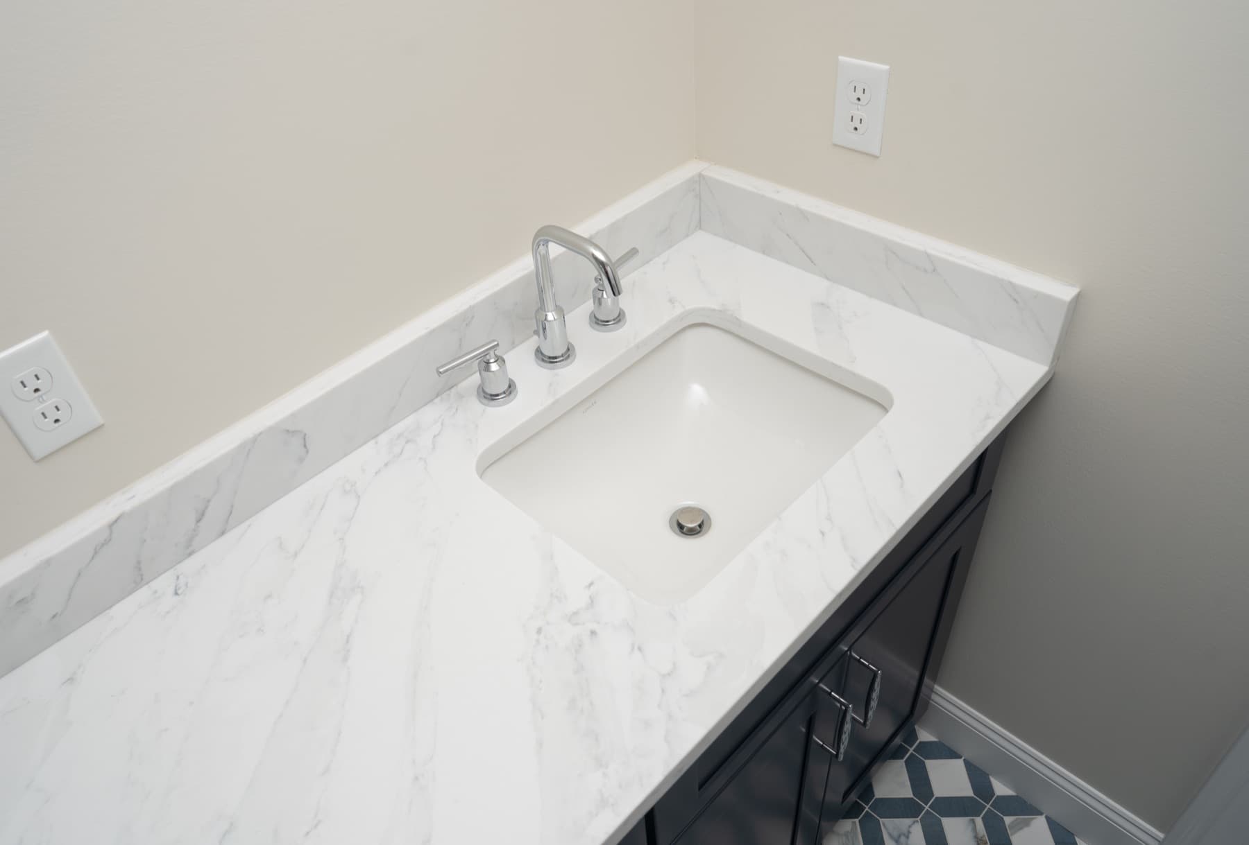 Undermount sink in a Marfil Grey quartz countertop with chrome faucet