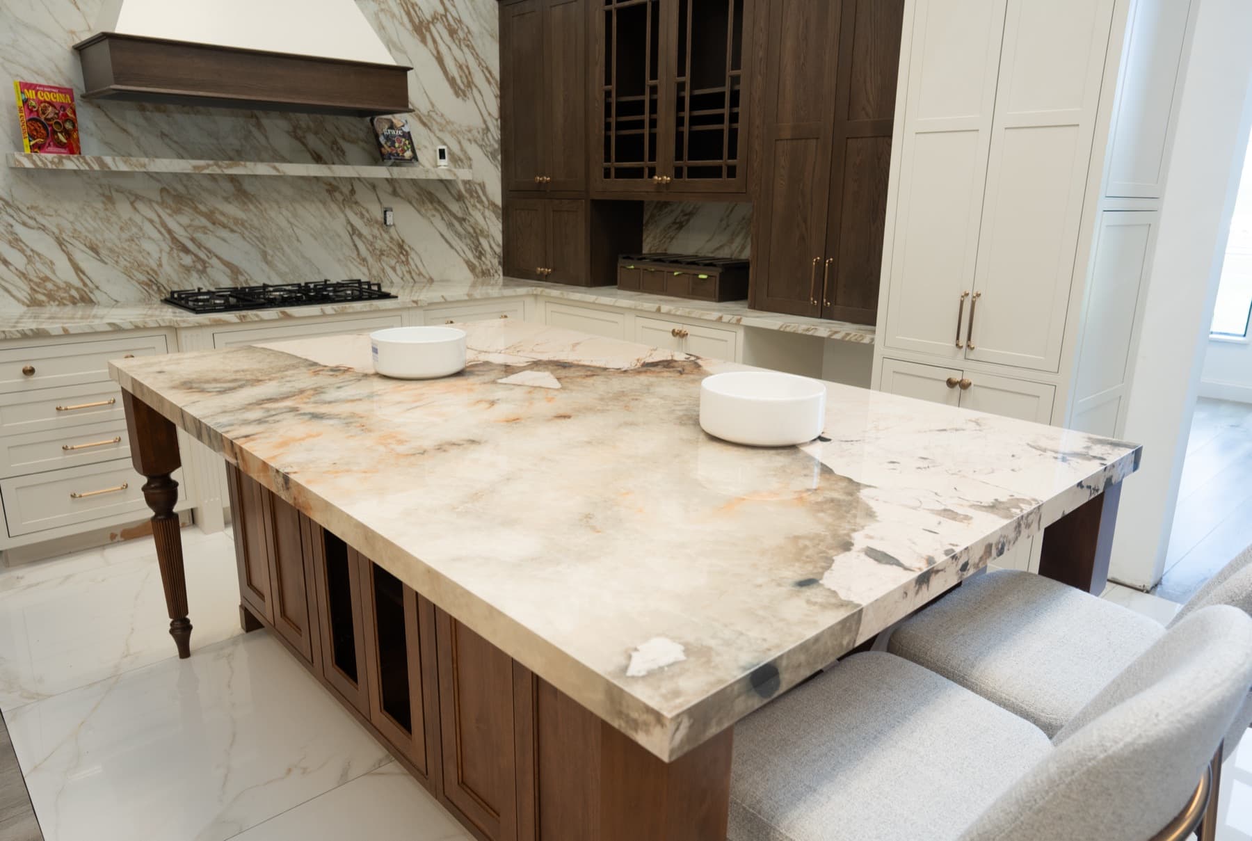 Oversized Magellano island with a thick mitered edge in a kitchen with dark wood and white cabinetry